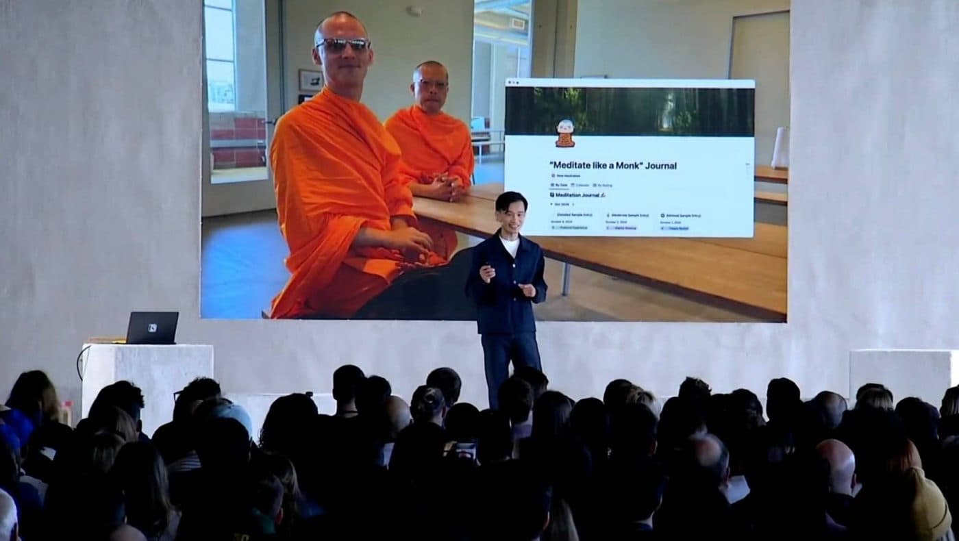Ivan Zhao on stage at Make with Notion, a photo of the two monks and their Meditate like a Monk journal on the screen behind him