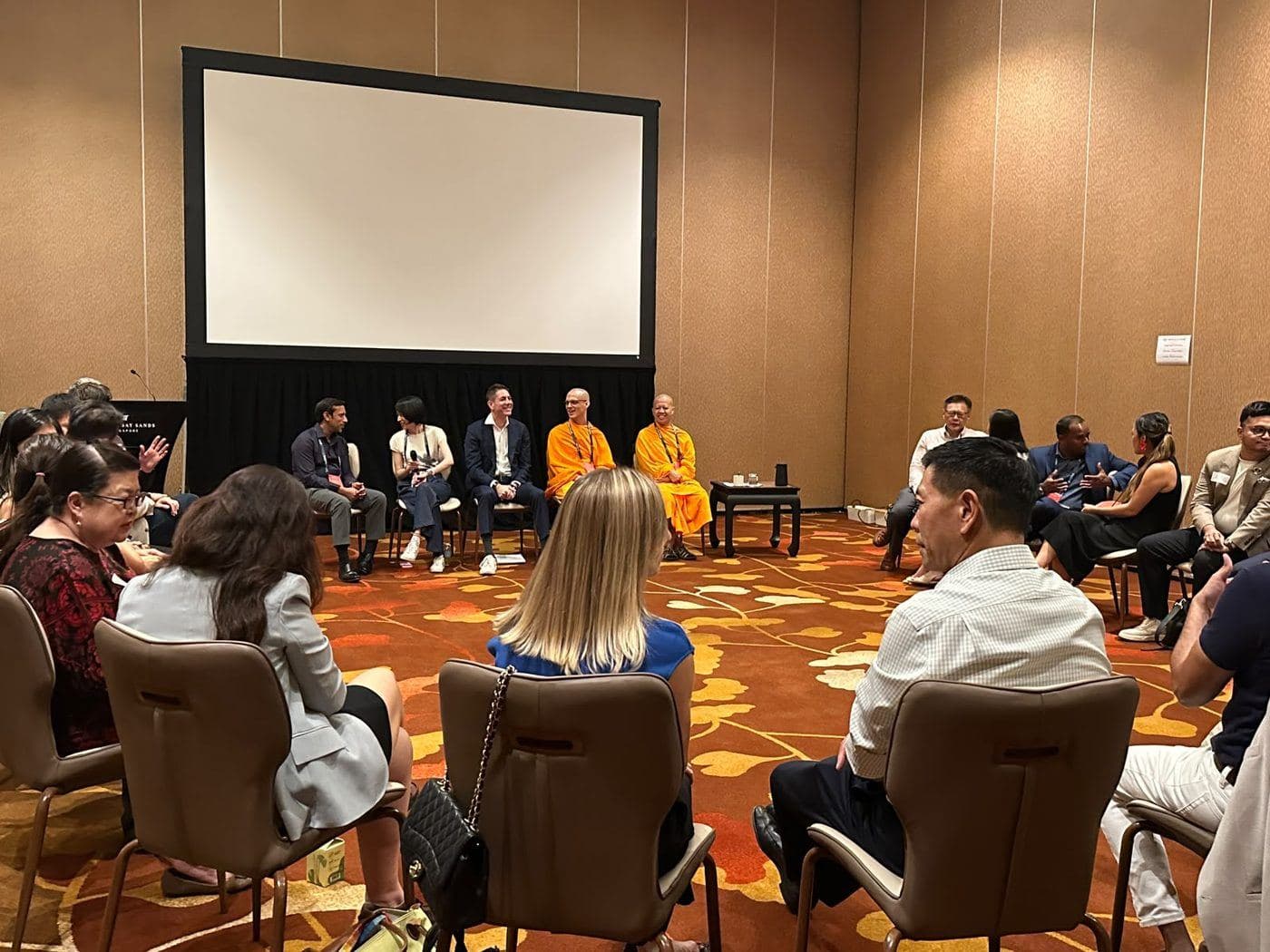 An audience seated in a circle for an evening session