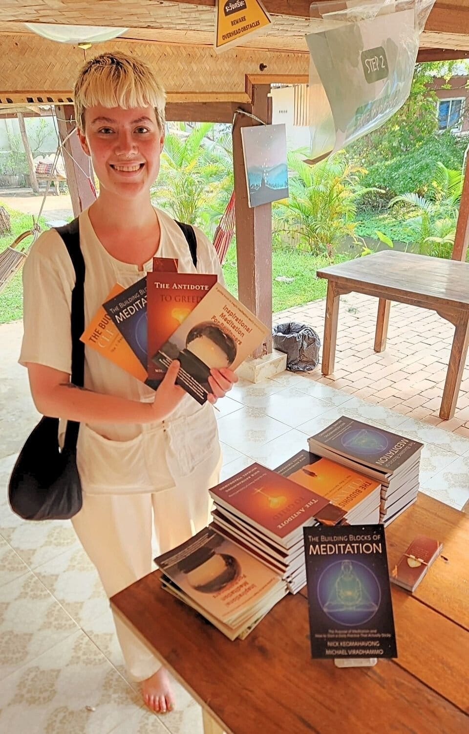 A visitor smiling as she holds a free copy of one of the books.